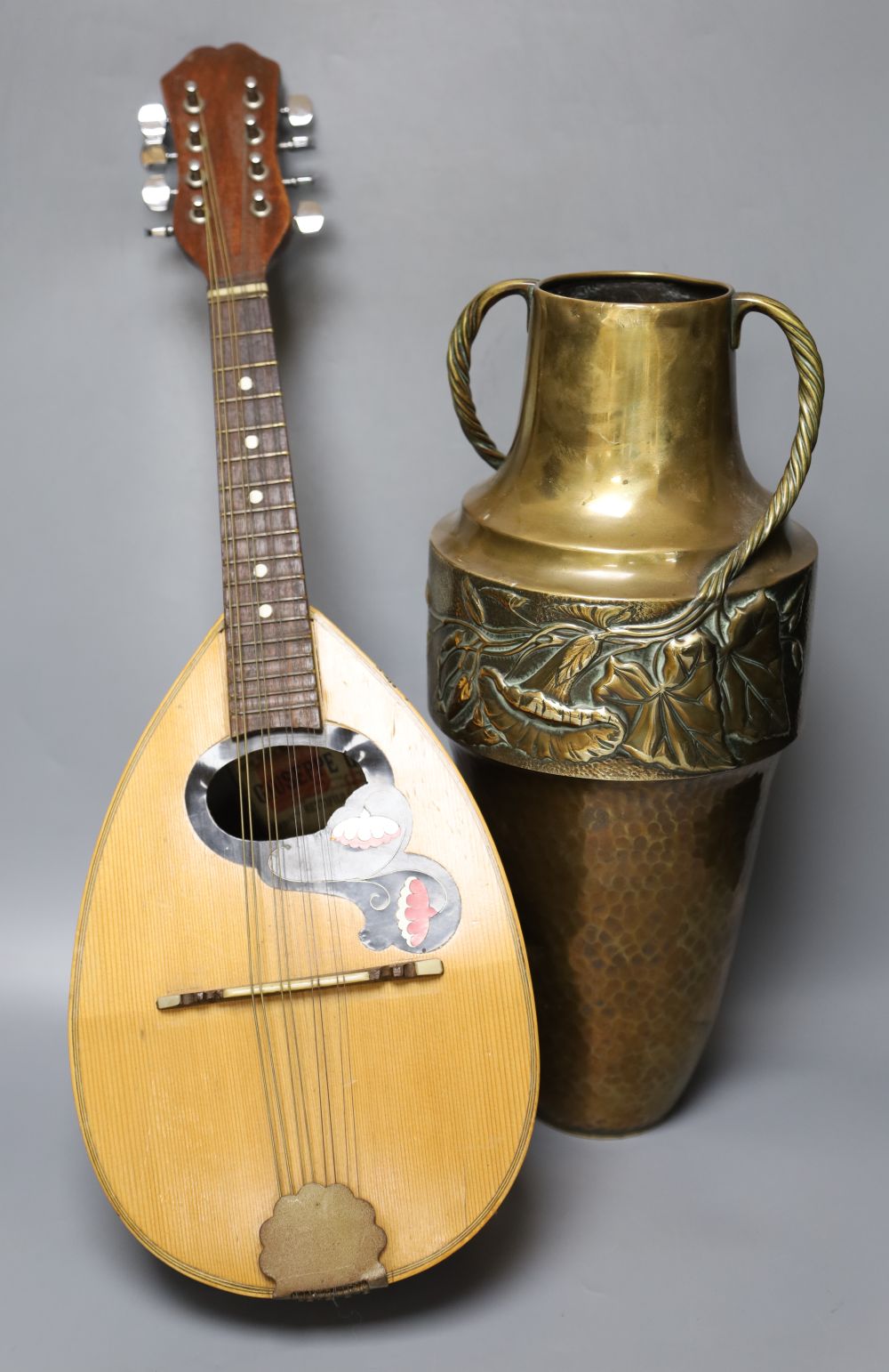 An Italian mandolin, makers label within, G. Quagila, and an embossed brass two handled vase, 43cm